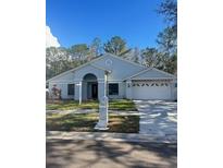 Charming single-Gathering home with a welcoming front porch, manicured lawn, and attached two-car garage at 9527 Pebble Glen Ave, Tampa, FL 33647