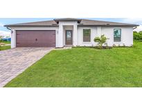 Single-story home with a two-car garage and landscaped lawn at 5307 Burgner St, Port Charlotte, FL 33981