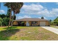 Single story home with attached garage and palm trees at 1402 Viscaya Dr, Port Charlotte, FL 33952
