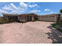 Charming single-story home featuring a brick facade, spacious driveway, and attached garage at 3931 E Eden Roc Cir, Tampa, FL 33634