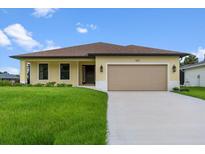 Exterior of a single-story home with a two-car garage and manicured lawn at 9187 Prospect Ave, Englewood, FL 34224
