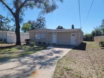 Charming single-story home with neutral paint, mature trees, and a concrete driveway at 4305 E Deleuil Ave, Tampa, FL 33610