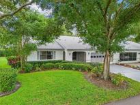 White single story home with green lawn and mature trees at 1606 Laughton Pl, Sun City Center, FL 33573