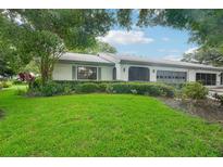 House exterior showcasing a well-maintained lawn and lush landscaping at 1606 Laughton Pl, Sun City Center, FL 33573