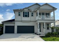 Two-story home featuring a light gray exterior, balcony, and a two-car garage at 4017 W Fig St, Tampa, FL 33609