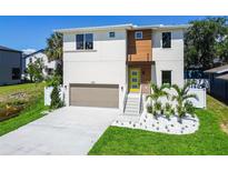 Contemporary two-story home with a well-manicured lawn, a two-car garage, and modern landscaping at 7615 S Swoope St, Tampa, FL 33616