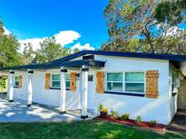 White house with a carport, wood shutters, and landscaped yard at 900 W County Line Rd, Lutz, FL 33548