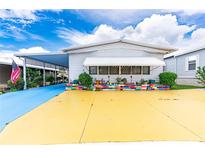 Mobile home with colorful landscaping and unique driveway at 7131 El Dewitt St, Zephyrhills, FL 33541
