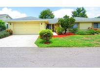 House exterior featuring a yellow house with attached garage and landscaping at 1306 Idlewood Dr # 53, Sun City Center, FL 33573
