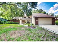 Two story home with attached garage and brick exterior at 35070 Smoketree Ln, Dade City, FL 33523