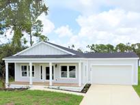 Charming single-story home with a front porch and attached garage at 18390 Fremont Ave, Port Charlotte, FL 33954