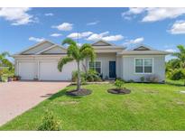Beautiful two-car garage home with a well-manicured lawn at 13333 Gershwin Ln, Port Charlotte, FL 33981