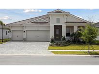 Charming single-story home with a three-car garage and professionally landscaped front yard at 10422 Longmeadow Ave, Parrish, FL 34219