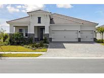 Beautiful home showcasing a well-manicured lawn, stone accents, and a spacious three-car garage at 10426 Longmeadow Ave, Parrish, FL 34219