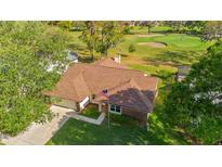 Beautiful aerial view of a house with a brown roof overlooking a golf course on a sunny day at 2618 Crestfield Dr, Valrico, FL 33596