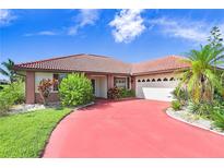 Brick home with red driveway, two car garage and lush landscaping at 1826 Wolf Laurel Dr, Sun City Center, FL 33573