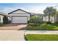 Attractive single-story home with a white garage door and landscaping at 18933 Sailors Delight Pass, Land O Lakes, FL 34638