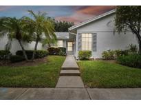 Front view of charming villa with walkway and well-manicured lawn at 4137 Edgewood Dr, Holiday, FL 34691