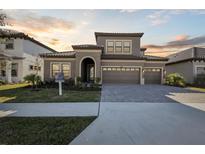 Two-story home with a three-car garage and paver driveway at 11218 Rustic Timber Loop, San Antonio, FL 33576