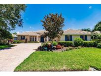 Single-story home with brick driveway and lush landscaping at 225 Pesaro Dr, North Venice, FL 34275