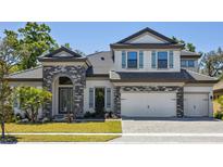 Charming two-story home featuring stone accents, a two-car garage, and a well-manicured lawn at 149 Hidden Estates Ct, Brandon, FL 33511