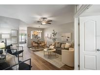 Bright living room with hardwood floors, cozy seating, and a view into the dining area at 16215 Swan View Cir, Odessa, FL 33556