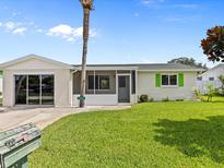 Charming ranch-style home with green shutters and a well-maintained lawn at 7035 Heath Dr, Port Richey, FL 34668