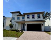 New two-story home features a brick-paver driveway, a two-car garage and a well-manicured lawn at 4021 W Santiago St, Tampa, FL 33629