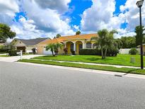 House exterior showcasing a well-maintained lawn and landscaping at 7827 Starfire Way, New Port Richey, FL 34654