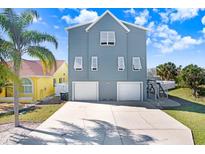 Two-story blue home with a two-car garage, steps leading to the second floor, and a concrete driveway at 944 Apollo Beach Blvd, Apollo Beach, FL 33572