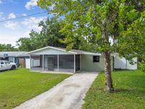 Charming ranch-style house with a screened porch and a spacious lawn at 7024 Filbert Ln, Tampa, FL 33637