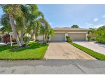Well-maintained house with a two-car garage and lush landscaping at 633 Tremont Greens Ln # 16, Sun City Center, FL 33573