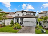 Two-story home with a white and brown exterior, two-car garage, and landscaped yard at 1039 Seagrape Dr, Ruskin, FL 33570