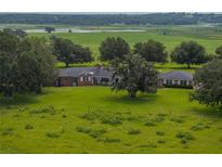 Expansive estate featuring a beautiful brick home, surrounded by lush greenery and mature trees at 34868 Prospect Rd, Dade City, FL 33525