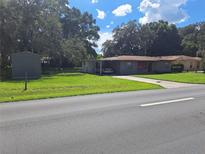 Image shows a ranch home with carport and storage shed at 5023 6Th St, Zephyrhills, FL 33542