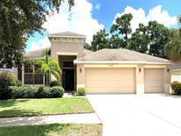 Two-story house with a three-car garage and landscaped yard at 10308 Holland Rd, Riverview, FL 33578