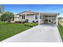 Charming single-story home features manicured lawn and an inviting front entrance with covered parking at 5733 Pawnee St, Zephyrhills, FL 33542