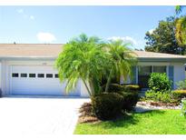 Single-story home with attached garage and lush landscaping at 2501 Lonigan Pl, Sun City Center, FL 33573