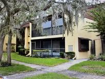 Two-story condo building with balconies, lush landscaping, and a walkway at 14105 Mossy Glen Ln # 202, Tampa, FL 33613