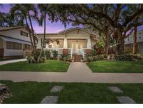Charming bungalow with a large front porch, mature trees and well-maintained lawn at 2010 W Dekle Ave, Tampa, FL 33606
