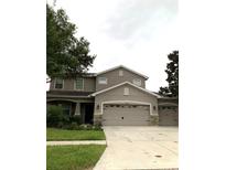 Two-story house with gray siding and stone accents at 32502 Summerglade Dr, Wesley Chapel, FL 33545