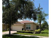 Tan house with a red tile roof and two car garage at 15953 Cobble Mill Dr, Wimauma, FL 33598