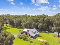 Stunning aerial view of a custom home on a lush, expansive lot with mature trees and plenty of green space at 3520 Leslie West Rd, Dover, FL 33527
