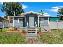 Newly renovated home with a charming front porch and well-maintained lawn at 8738 N Tangerine Pl, Tampa, FL 33617