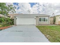 House exterior featuring a single-car garage and a well-maintained lawn at 4509 Tidal Pond Rd, New Port Richey, FL 34652