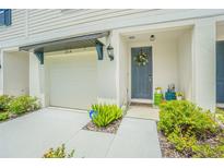 Townhouse with a modern gray door and well-maintained landscaping at 2714 Chestnut Creek Pl, Brandon, FL 33510