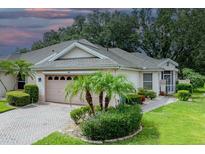 Charming one-story home boasts a manicured front yard, brick driveway, and an attached two-car garage at 604 Masterpiece Dr # 604, Sun City Center, FL 33573