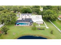 Aerial view of a house with a pool, garden, and large backyard at 17513 Marsh Rd, Lutz, FL 33558