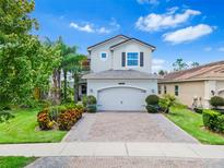 Two-story house with a gray exterior, landscaping, and a two-car garage at 2847 Tarragona Way, Wesley Chapel, FL 33543