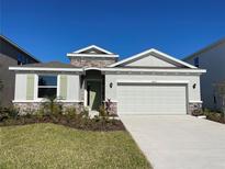 Single-story house with light-colored siding, attached garage, and landscaped lawn at 18215 Fattoria Ter, Lakewood Ranch, FL 34211